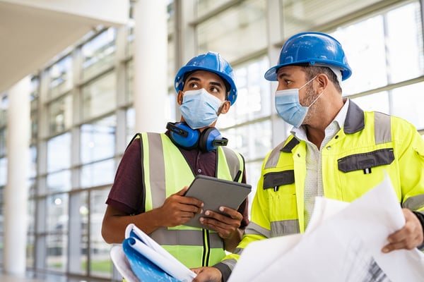 Architect and engineer discussing on construction site with plan