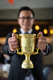 Businessman holding a golden trophy to celebrate and recognize his good work