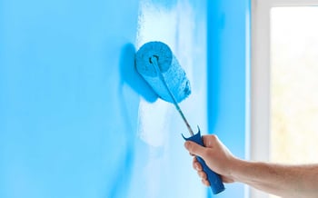 Painting room wall with paint roller