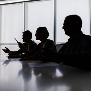 Silhouette of executives hearing pitch for new tool and asking questions