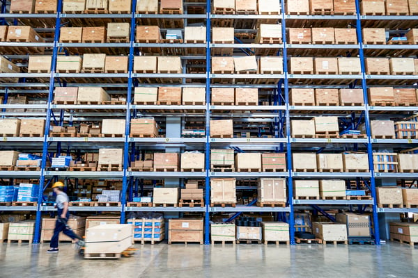 coworker carrying cardboard box in warehouse being proactive