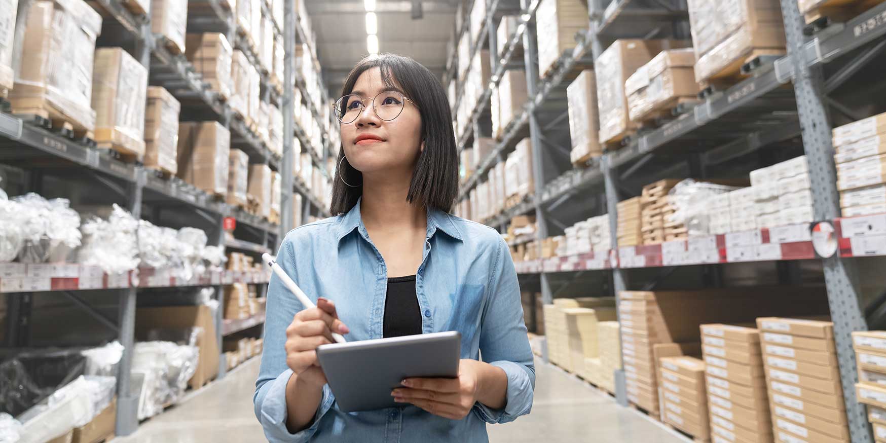 Woman making decisions while stocktaking inventory in warehouse