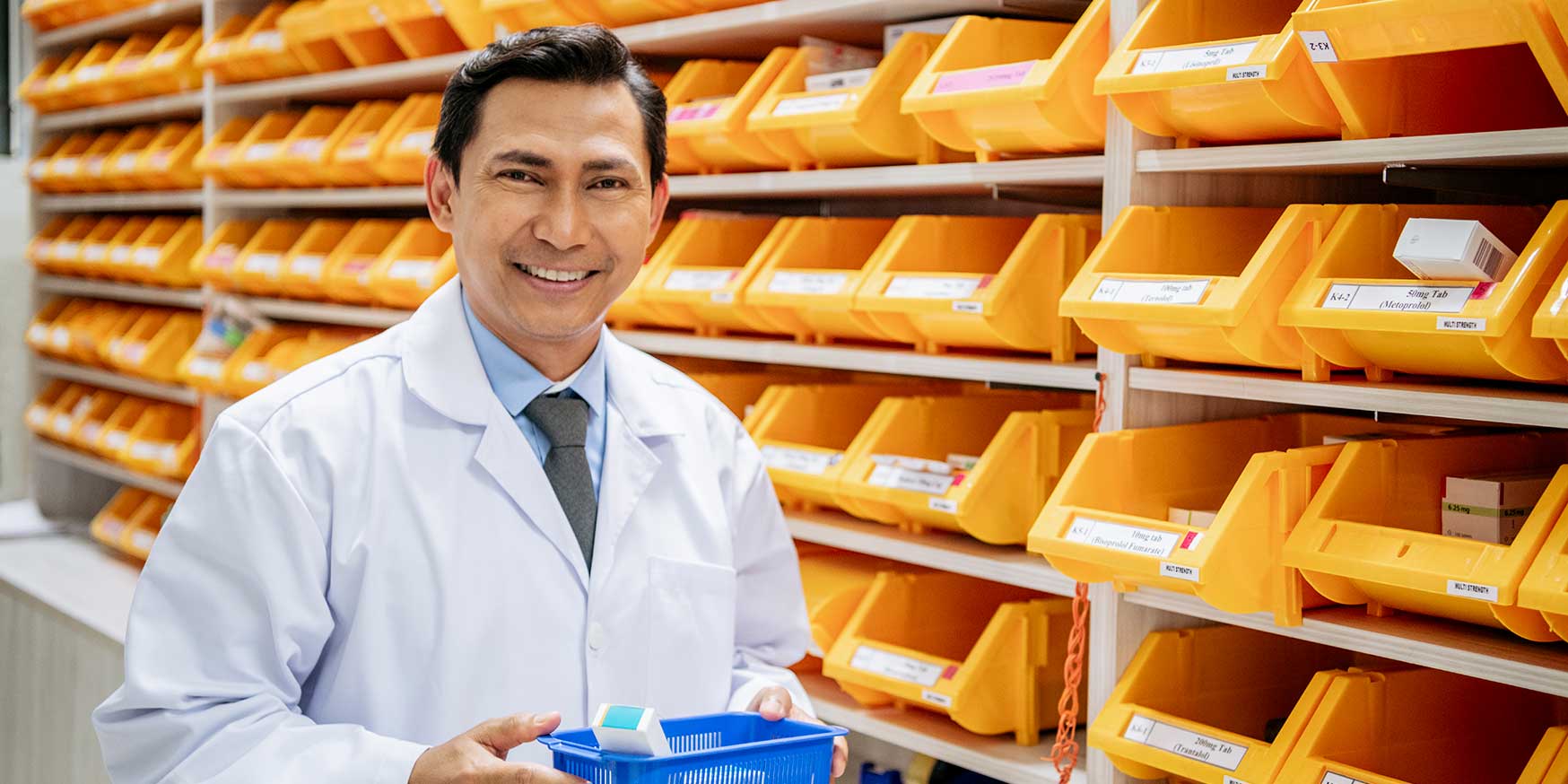 Pharmacist holding medication tray in pharmacy