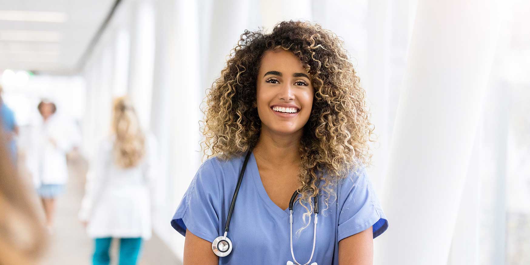 Nurse smiles for camera in elevated walkway