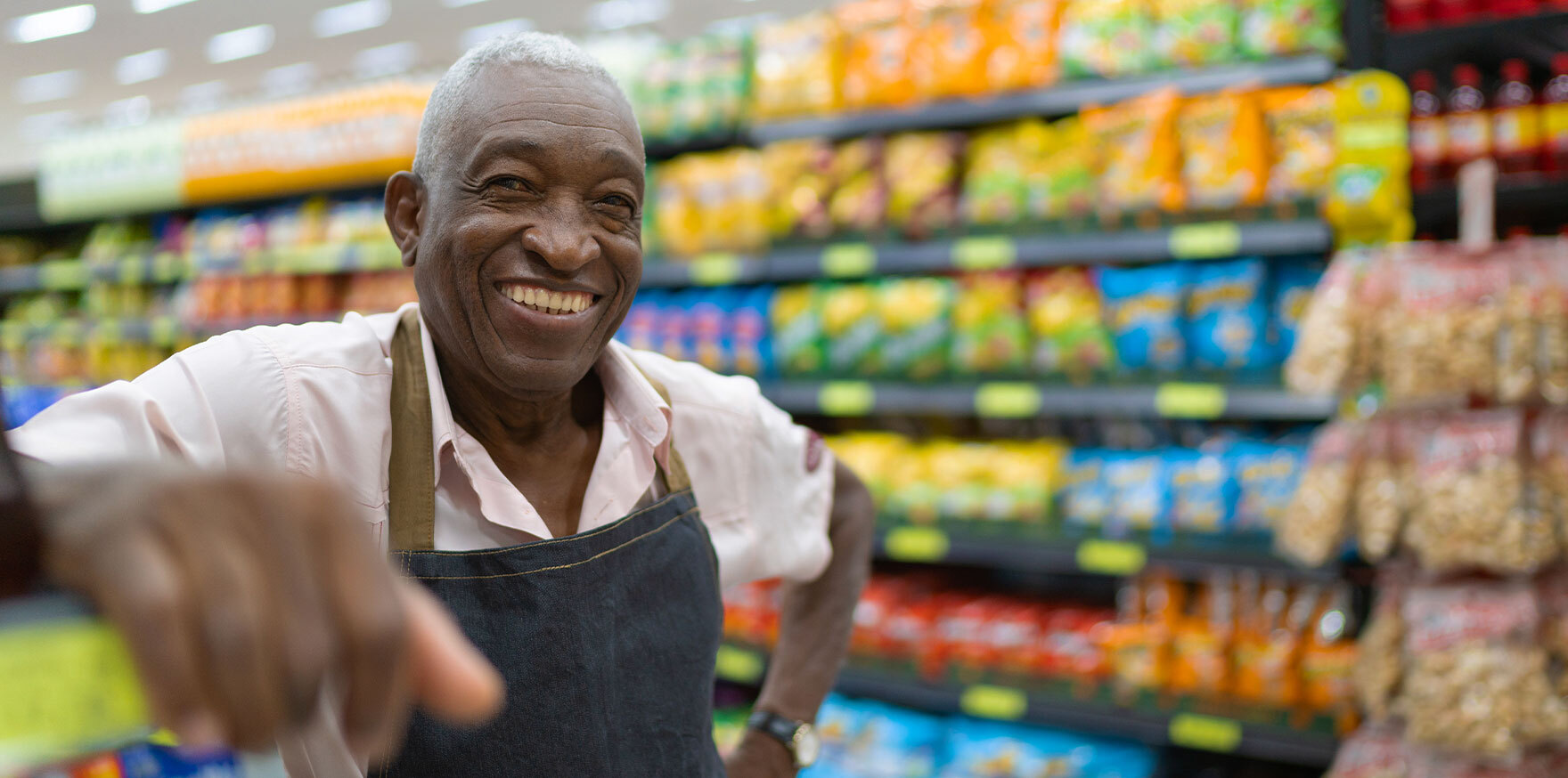 Keep candidates happy: portrait of older retail worker beaming a smile while in the aisle of store looking into camera