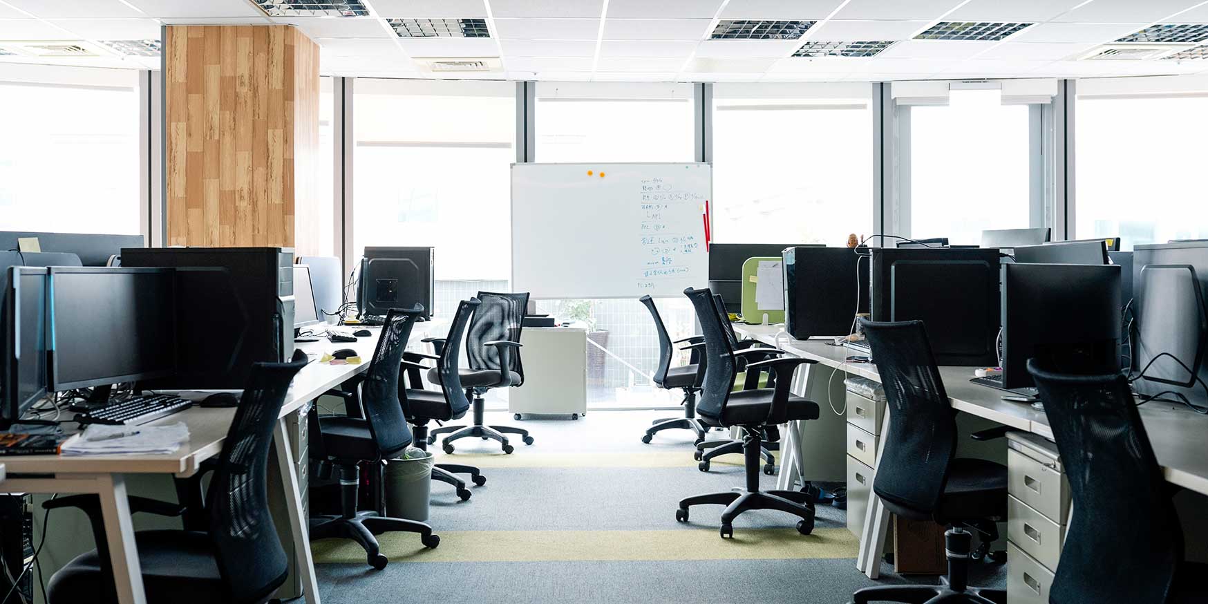 Empty chairs and Desktop computers at desks in office