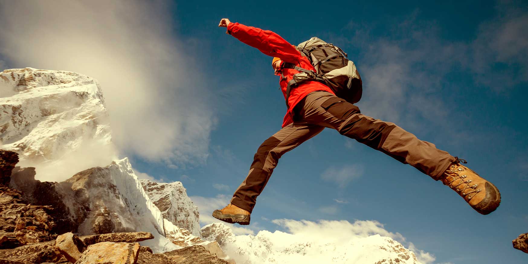 Hiker dangerously jumps on a rock near Everest in Nepal