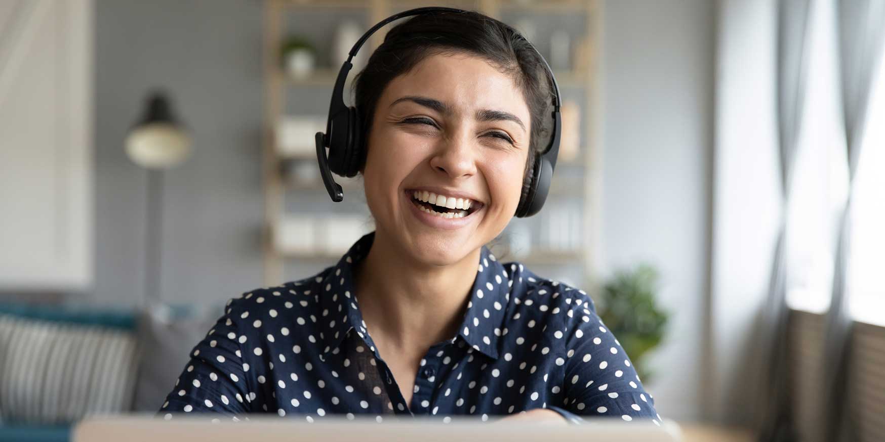 person working for a call center enjoying a call with a customer and laughing