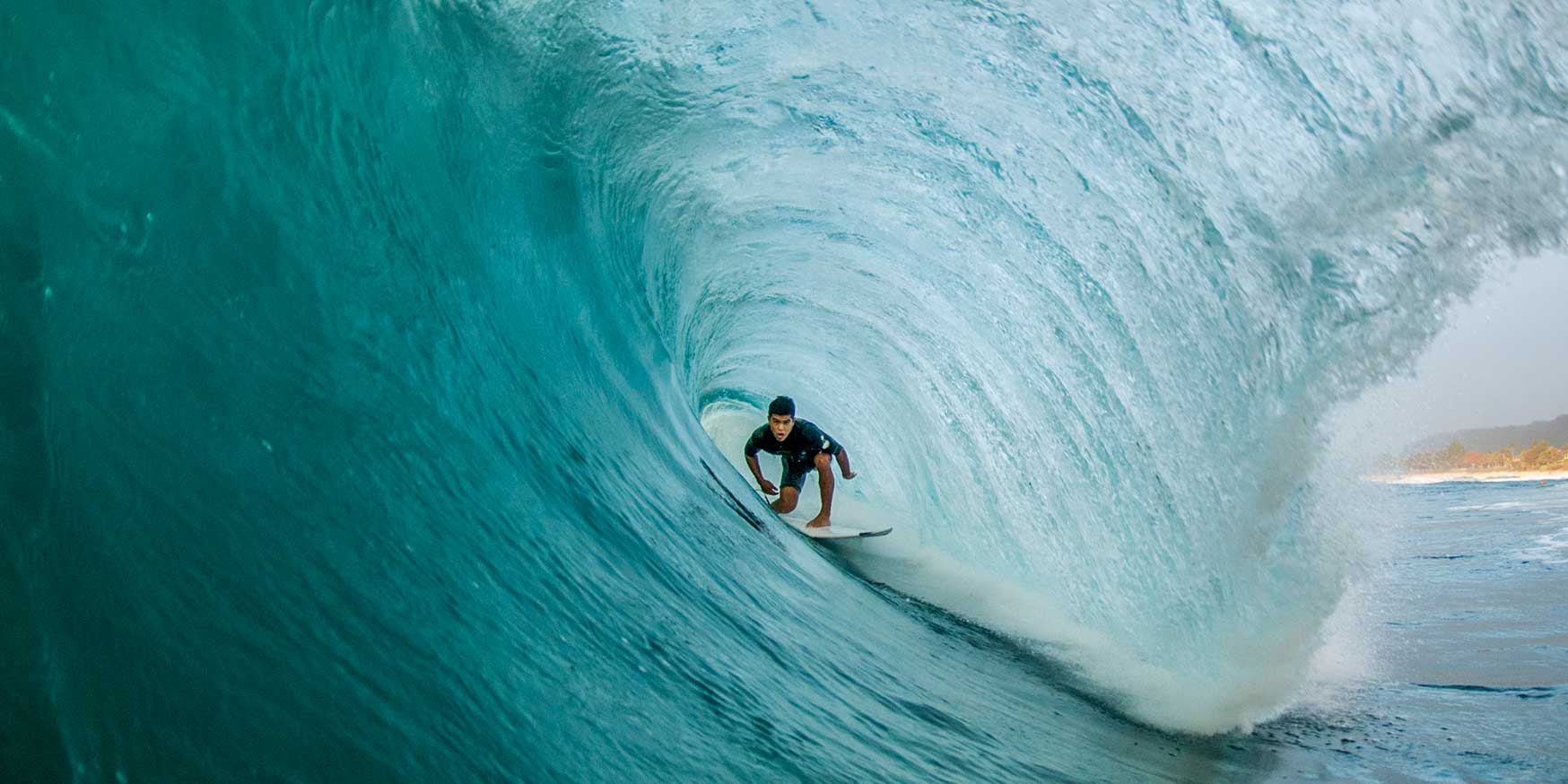 Professional surfer is perfectly pitted deep within a North Shore barrel wave